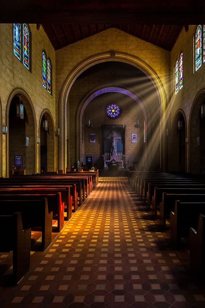 Golden light of sunrays coming into the stained glass windows of St Leos Abbey in Florida